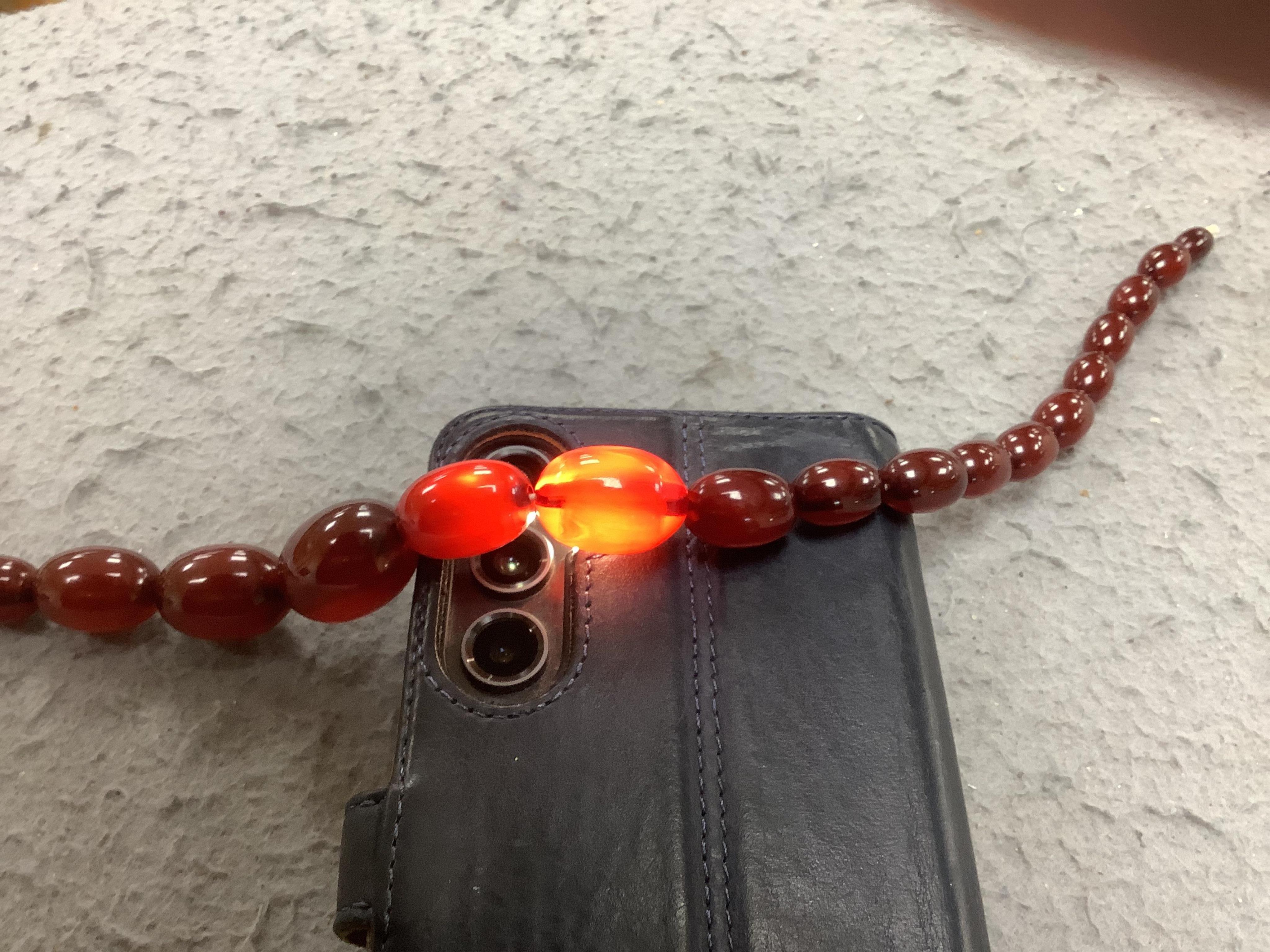 A single strand graduated oval simulated cherry amber bead necklace, 38cm, gross weight 41 grams. Condition - poor to fair